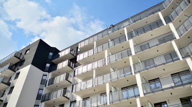Güneşli bir günde modern Avrupa konut mimarisi. Yeni çok katlı konut binasının dışı. Tüketiciler için konut satışı ve kiralama kavramı. Modern pencere ve balkonlar.