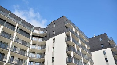 Güneşli bir günde modern Avrupa konut mimarisi. Yeni çok katlı konut binasının dışı. Tüketiciler için konut satışı ve kiralama kavramı. Modern pencere ve balkonlar.