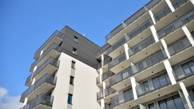 Güneşli bir günde modern Avrupa konut mimarisi. Yeni çok katlı konut binasının dışı. Tüketiciler için konut satışı ve kiralama kavramı. Modern pencere ve balkonlar.