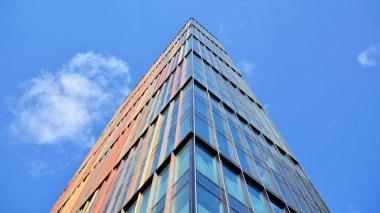 Gökyüzü arka planında cam cepheli modern ofis binası. Yansıtıcı camla kaplı modern bir binanın cam kaplamalı cephesinin soyut görüntüsü..