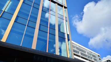 Gökyüzü arka planında cam cepheli modern ofis binası. Yansıtıcı camla kaplı modern bir binanın cam kaplamalı cephesinin soyut görüntüsü..