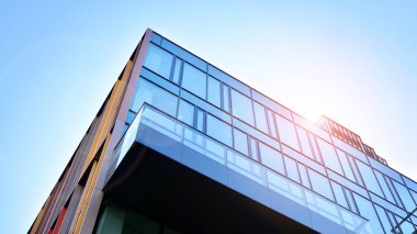 Gökyüzü arka planında cam cepheli modern ofis binası. Yansıtıcı camla kaplı modern bir binanın cam kaplamalı cephesinin soyut görüntüsü..