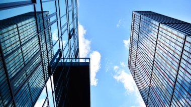 Gökyüzü arka planında cam cepheli modern ofis binası. Yansıtıcı camla kaplı modern bir binanın cam kaplamalı cephesinin soyut görüntüsü..