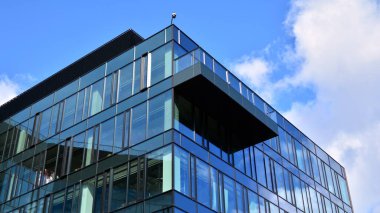 Gökyüzü arka planında cam cepheli modern ofis binası. Yansıtıcı camla kaplı modern bir binanın cam kaplamalı cephesinin soyut görüntüsü..