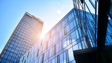 Gökyüzü arka planında cam cepheli modern ofis binası. Yansıtıcı camla kaplı modern bir binanın cam kaplamalı cephesinin soyut görüntüsü..