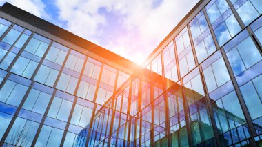  Bulutlu mavi gökyüzü arka planlı cam binalar. Camın çelik açık mavi arka planına geniş açılı bir bakış açısı. Ticari modern geleceğin şehri. Başarılı mimari iş kavramı.