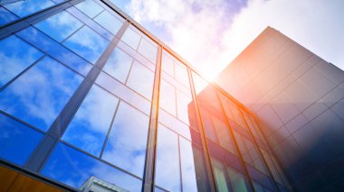  Bulutlu mavi gökyüzü arka planlı cam binalar. Camın çelik açık mavi arka planına geniş açılı bir bakış açısı. Ticari modern geleceğin şehri. Başarılı mimari iş kavramı.