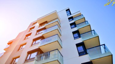 Avrupa 'da modern apartman mimarisi. Yenilikçi ve yerleşik dostane mimari çözümler. Arka planda mavi gökyüzü. Güneş ışığıyla.