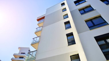 Avrupa 'da modern apartman mimarisi. Yenilikçi ve yerleşik dostane mimari çözümler. Arka planda mavi gökyüzü. Güneş ışığıyla.