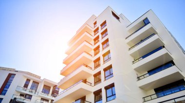 Avrupa 'da modern apartman mimarisi. Yenilikçi ve yerleşik dostane mimari çözümler. Arka planda mavi gökyüzü. Güneş ışığıyla.