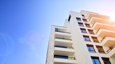 Avrupa 'da modern apartman mimarisi. Yenilikçi ve yerleşik dostane mimari çözümler. Arka planda mavi gökyüzü. Güneş ışığıyla.