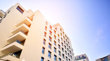 Avrupa 'da modern apartman mimarisi. Yenilikçi ve yerleşik dostane mimari çözümler. Arka planda mavi gökyüzü. Güneş ışığıyla.