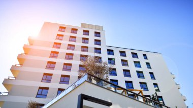 Avrupa 'da modern apartman mimarisi. Yenilikçi ve yerleşik dostane mimari çözümler. Arka planda mavi gökyüzü. Güneş ışığıyla.
