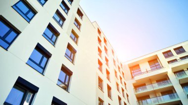 Avrupa 'da modern apartman mimarisi. Yenilikçi ve yerleşik dostane mimari çözümler. Arka planda mavi gökyüzü. Güneş ışığıyla.