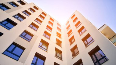 Avrupa 'da modern apartman mimarisi. Yenilikçi ve yerleşik dostane mimari çözümler. Arka planda mavi gökyüzü. Güneş ışığıyla.