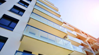 Avrupa 'da modern apartman mimarisi. Yenilikçi ve yerleşik dostane mimari çözümler. Arka planda mavi gökyüzü. Güneş ışığıyla.
