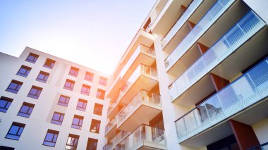 Avrupa 'da modern apartman mimarisi. Yenilikçi ve yerleşik dostane mimari çözümler. Arka planda mavi gökyüzü. Güneş ışığıyla.