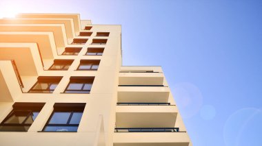 Avrupa 'da modern apartman mimarisi. Yenilikçi ve yerleşik dostane mimari çözümler. Arka planda mavi gökyüzü. Güneş ışığıyla.