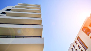 Avrupa 'da modern apartman mimarisi. Yenilikçi ve yerleşik dostane mimari çözümler. Arka planda mavi gökyüzü. Güneş ışığıyla.