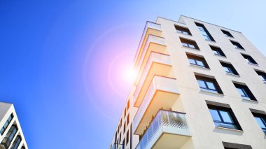 Avrupa 'da modern apartman mimarisi. Yenilikçi ve yerleşik dostane mimari çözümler. Arka planda mavi gökyüzü. Güneş ışığıyla.