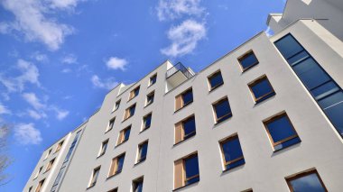 Modern apartman binaları ve şehirde yeni şehir manzarası olan bir yerleşim yeri. Beyaz yüzlü apartman dairesi. Kare camlı modern minimalist mimari kazandı.