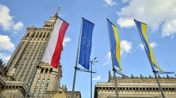 Varşova, Polonya. 28.04.2022. Polonya, Avrupa Birliği ve Ukrayna bayrakları Varşova Kültür Sarayı 'nın arka planına karşı