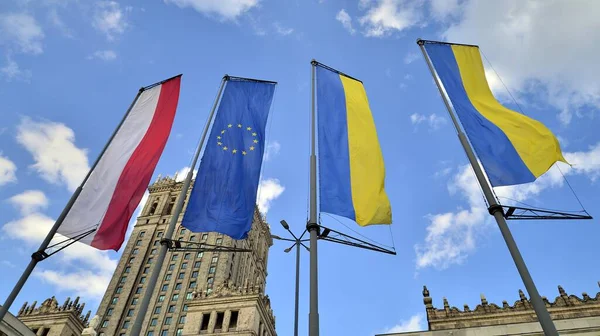 Varşova, Polonya. 28.04.2022. Polonya, Avrupa Birliği ve Ukrayna bayrakları Varşova Kültür Sarayı 'nın arka planına karşı