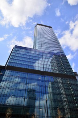 Avrupa 'daki gökdelen binasının siluetine karşı güneş ışığıyla aydınlatılan güzel şehir manzarası. Yüksek cam ve çelik bina manzaralı.