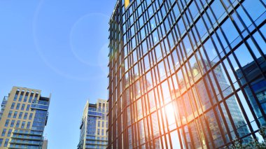 Mavi gökyüzünü yansıtan modern mimariye sahip şehir manzarası. İş ve finans binaları. 