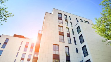 Yeşil yerleşim bölgesinde yeni daireleri olan modern bir yerleşim yeri. Çevre mimarisi. Yeşil ağaç ve yeni apartman. Doğanın ve modernliğin ahengi.