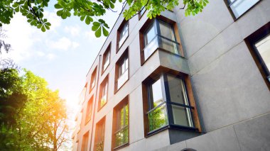 Yeşil yerleşim bölgesinde yeni daireleri olan modern bir yerleşim yeri. Çevre mimarisi. Yeşil ağaç ve yeni apartman. Doğanın ve modernliğin ahengi.