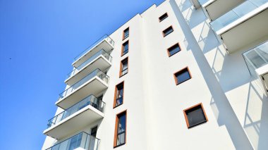 Modern lüks konut dairesi. Güneşli bir günde modern apartman binası. Mavi gökyüzü olan bir apartman. Modern bir apartmanın cephesi.