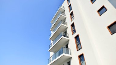 Modern lüks konut dairesi. Güneşli bir günde modern apartman binası. Mavi gökyüzü olan bir apartman. Modern bir apartmanın cephesi.