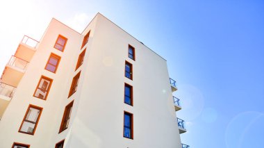 Modern lüks konut dairesi. Güneşli bir günde modern apartman binası. Mavi gökyüzü olan bir apartman. Modern bir apartmanın cephesi.