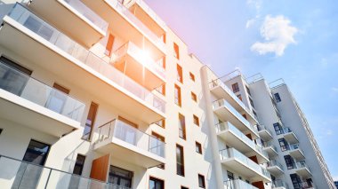 Modern lüks konut dairesi. Güneşli bir günde modern apartman binası. Mavi gökyüzü olan bir apartman. Modern bir apartmanın cephesi.