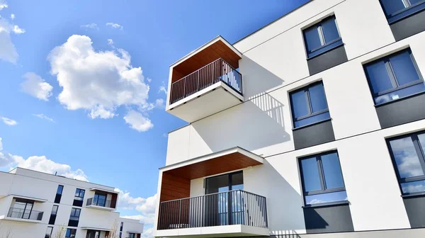 Balkonları ve bulutlu mavi gökyüzü olan beyaz bir yerleşim yerinin parçası. Güneşli bir günde modern apartmanda mimari detaylar.