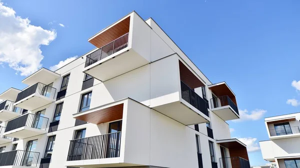 Balkonları ve bulutlu mavi gökyüzü olan beyaz bir yerleşim yerinin parçası. Güneşli bir günde modern apartmanda mimari detaylar.