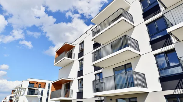 Balkonları ve bulutlu mavi gökyüzü olan beyaz bir yerleşim yerinin parçası. Güneşli bir günde modern apartmanda mimari detaylar.