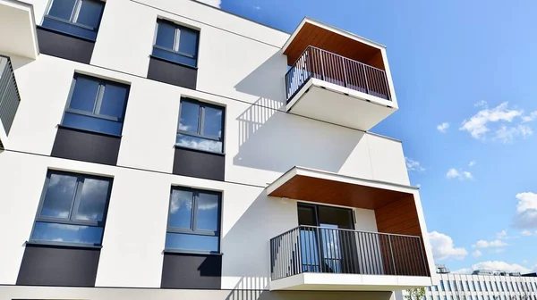 Balkonları ve bulutlu mavi gökyüzü olan beyaz bir yerleşim yerinin parçası. Güneşli bir günde modern apartmanda mimari detaylar.