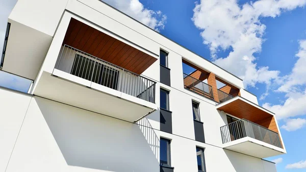 Balkonları ve bulutlu mavi gökyüzü olan beyaz bir yerleşim yerinin parçası. Güneşli bir günde modern apartmanda mimari detaylar.