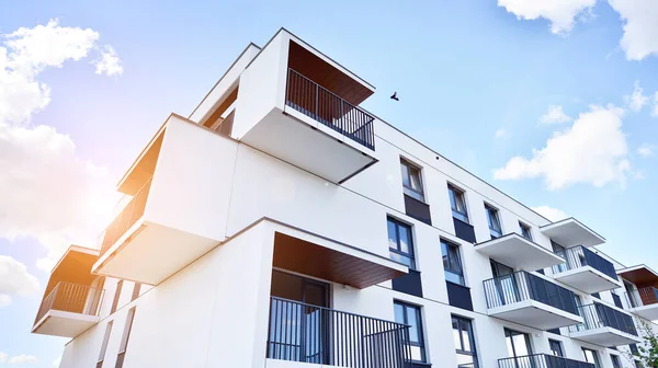 Balkonları ve bulutlu mavi gökyüzü olan beyaz bir yerleşim yerinin parçası. Güneşli bir günde modern apartmanda mimari detaylar.