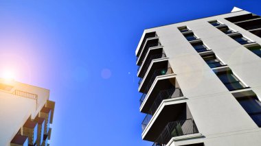 Apartman, ev ve dış görünüş mimarisi ve açık hava tesisleri. Arka planda mavi gökyüzü. Gün doğumunda gün ışığı.