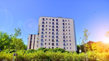Apartman, ev ve dış görünüş mimarisi ve açık hava tesisleri. Arka planda mavi gökyüzü. Gün doğumunda gün ışığı.