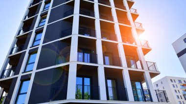 Apartman, ev ve dış görünüş mimarisi ve açık hava tesisleri. Arka planda mavi gökyüzü. Gün doğumunda gün ışığı.