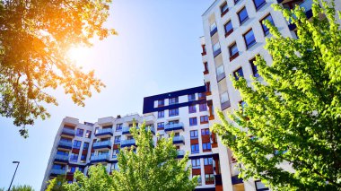 Apartman, ev ve dış görünüş mimarisi ve açık hava tesisleri. Arka planda mavi gökyüzü. Gün doğumunda gün ışığı.