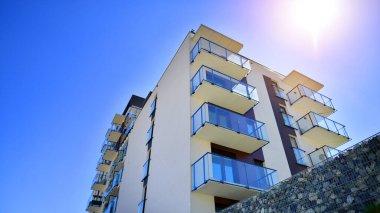 Apartman, ev ve dış görünüş mimarisi ve açık hava tesisleri. Arka planda mavi gökyüzü. Gün doğumunda gün ışığı.