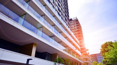 Çok katlı, modern bir apartmanın dış cephesi, pencereleri ve balkonları..