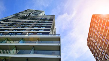 Çok katlı, modern bir apartmanın dış cephesi, pencereleri ve balkonları..