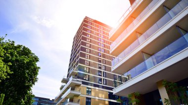 Çok katlı, modern bir apartmanın dış cephesi, pencereleri ve balkonları..