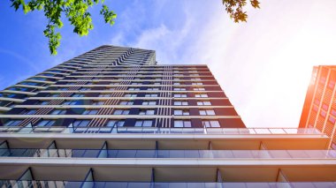 Çok katlı, modern bir apartmanın dış cephesi, pencereleri ve balkonları..
